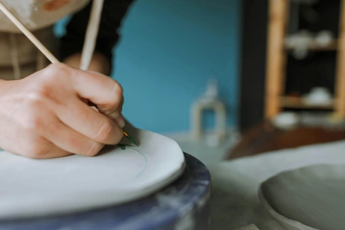 Someone painting plate on spinning wheel