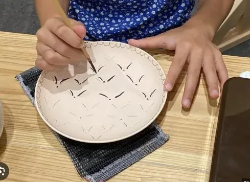 Woman painting plate